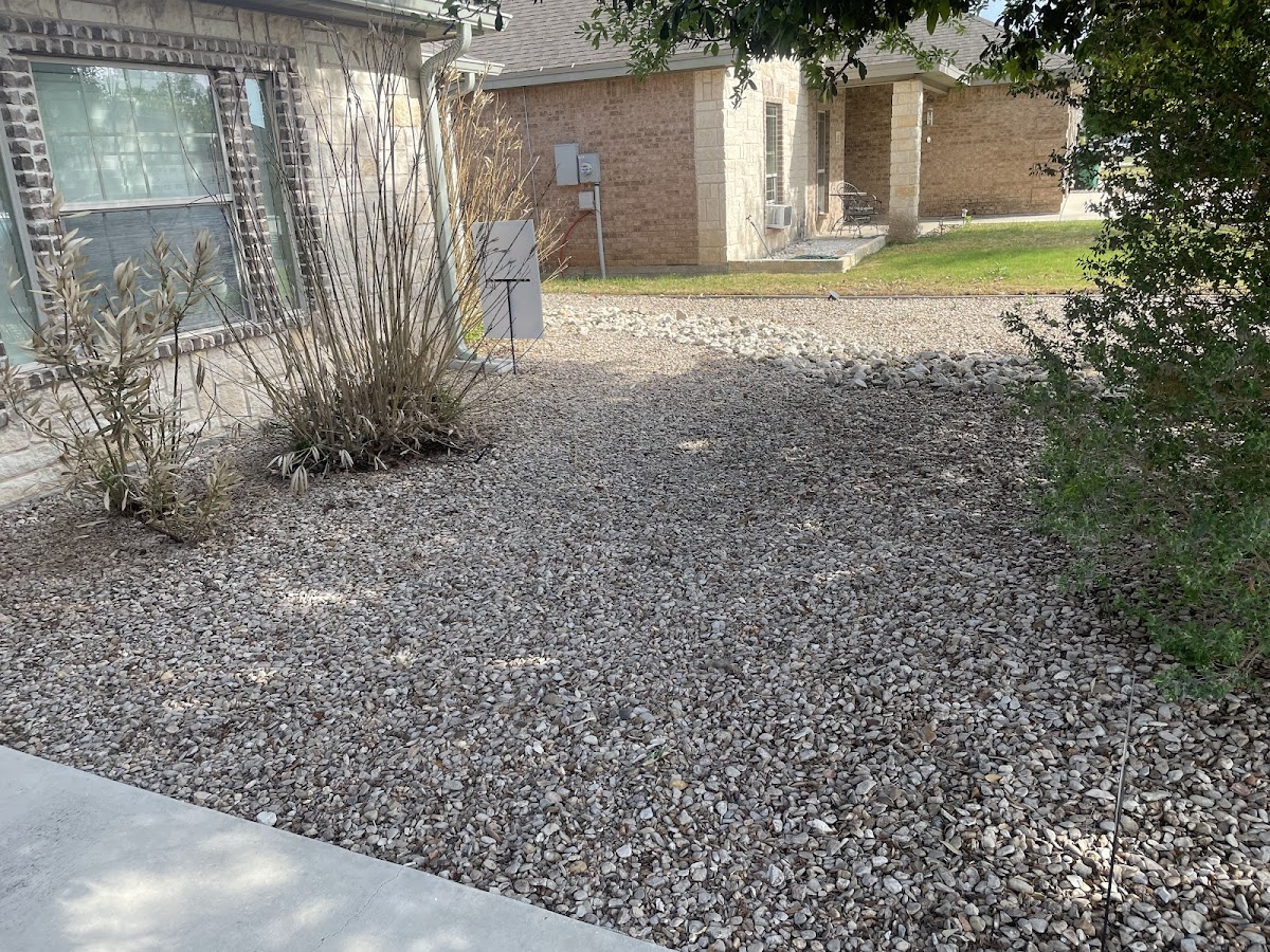 Neat gravel xeriscaping in front of a brick home